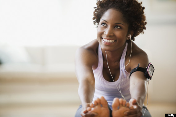 Black woman stretching and listening to mp3 player