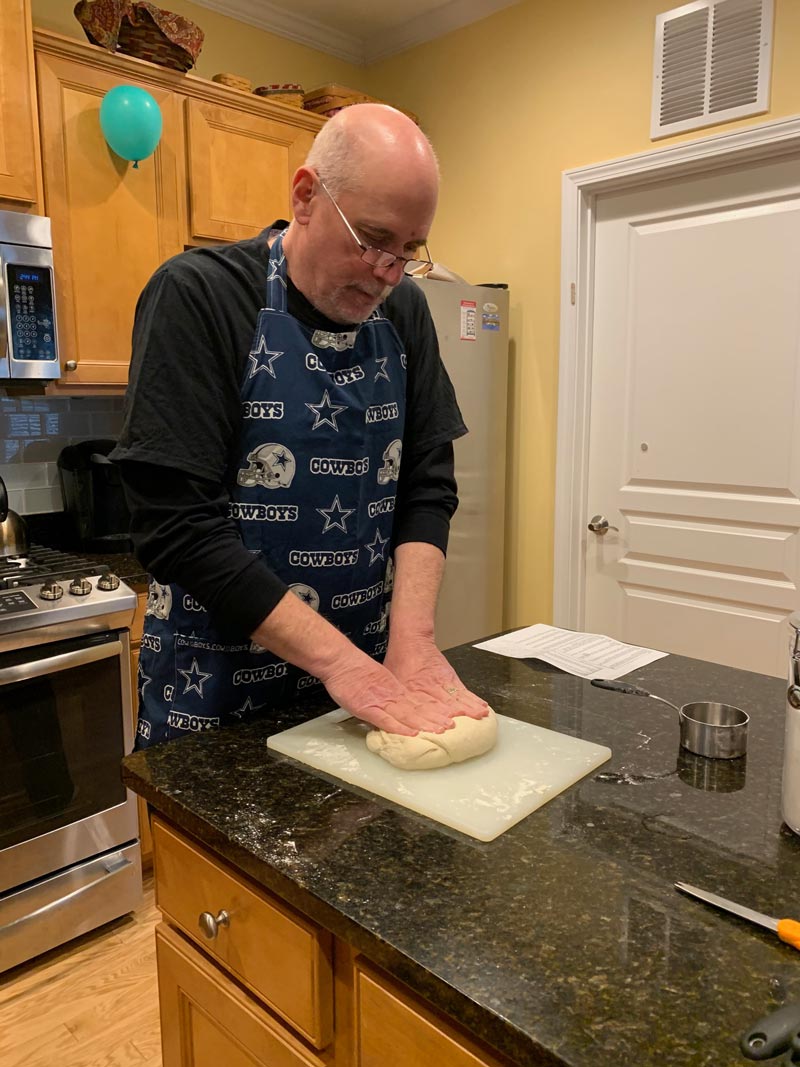 Man kneading dough in the kitchen.