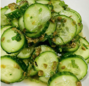 bright green cucumber and caper salad displayed on a white plate