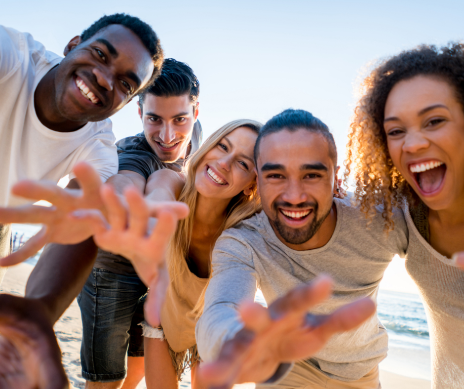 a diverse group of adult friends taking a selfie on the beach